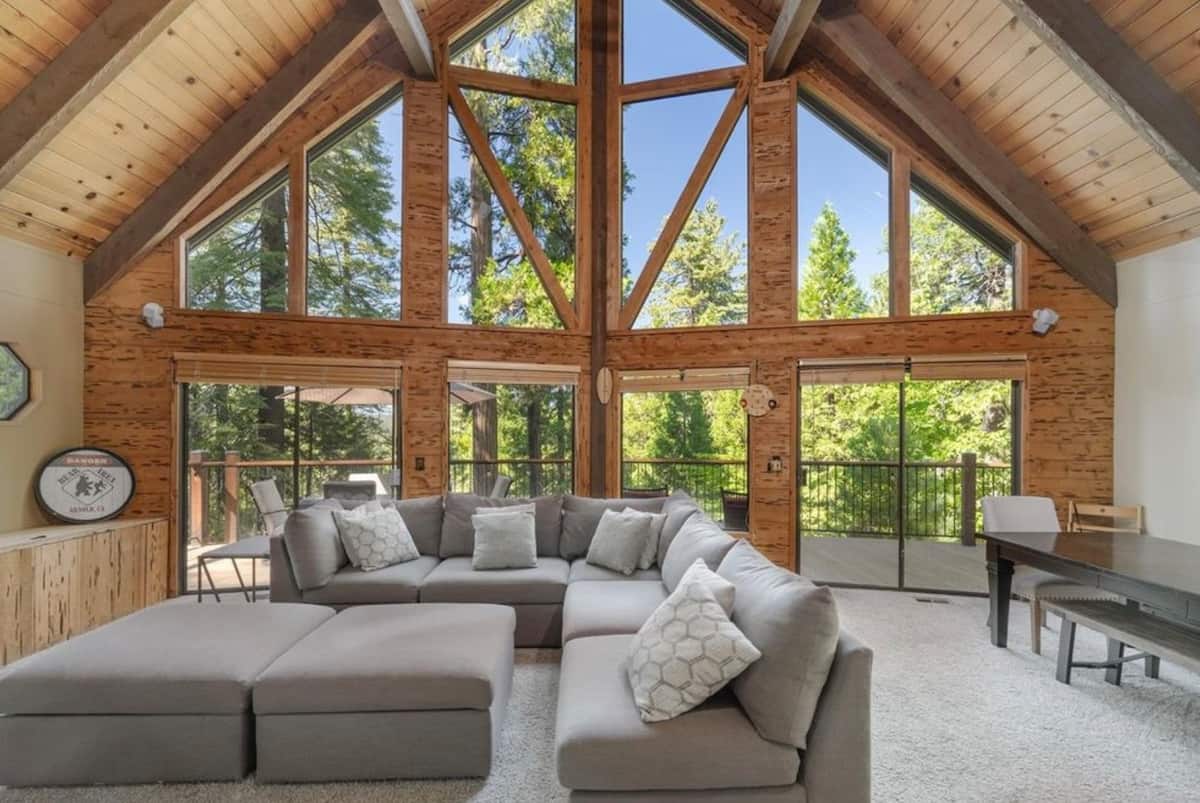 Cathedral great room with panoramic forest windows