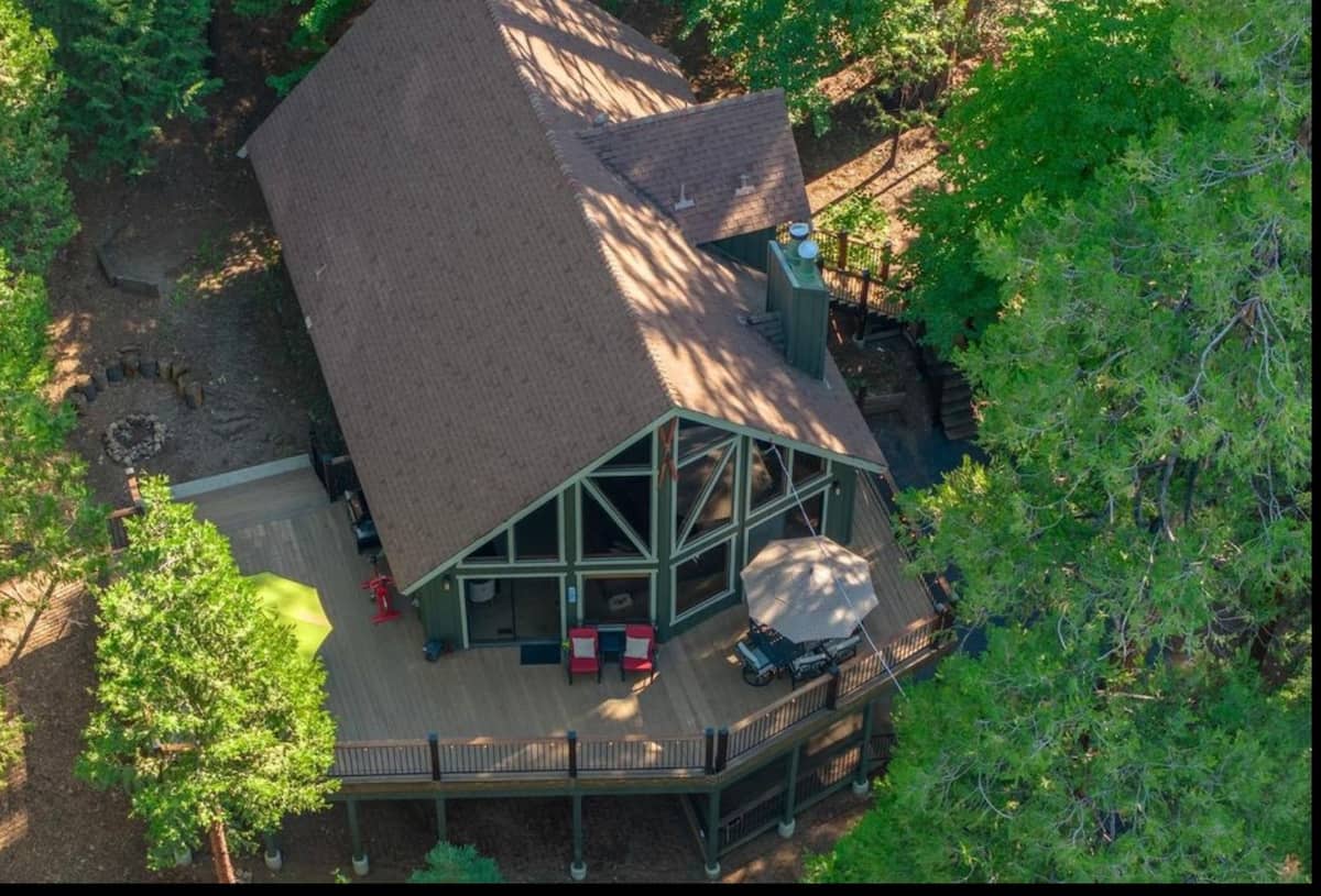 Aerial view of the cabin and wraparound deck in the forest