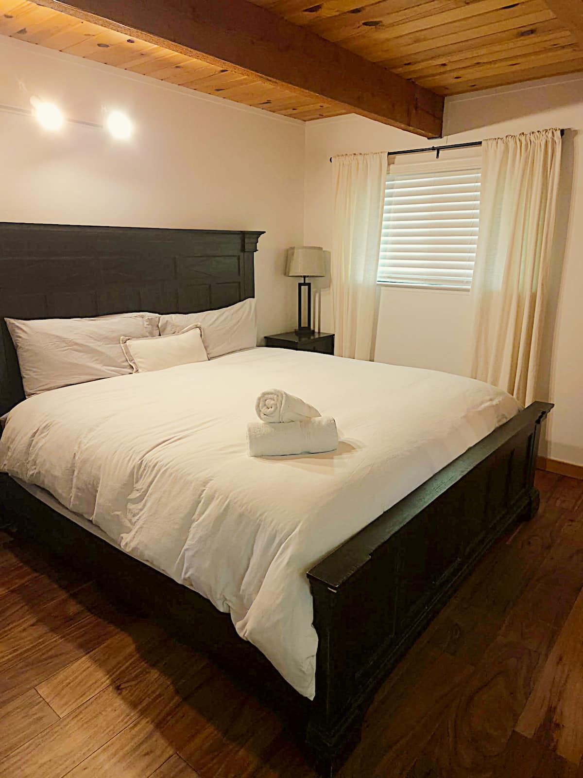 Cozy king bedroom with warm wood ceiling