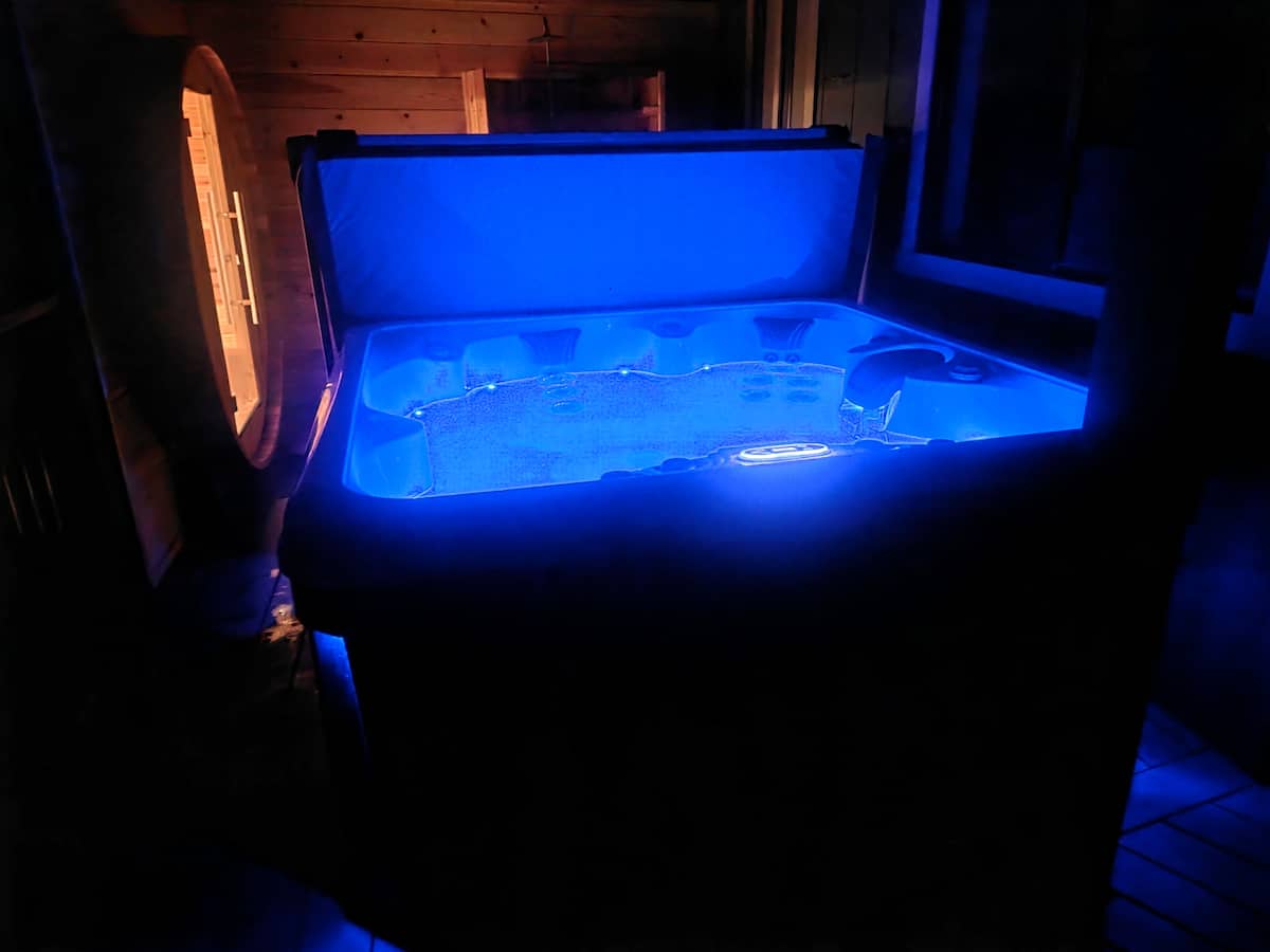 Private hot tub glowing beneath the trees at night