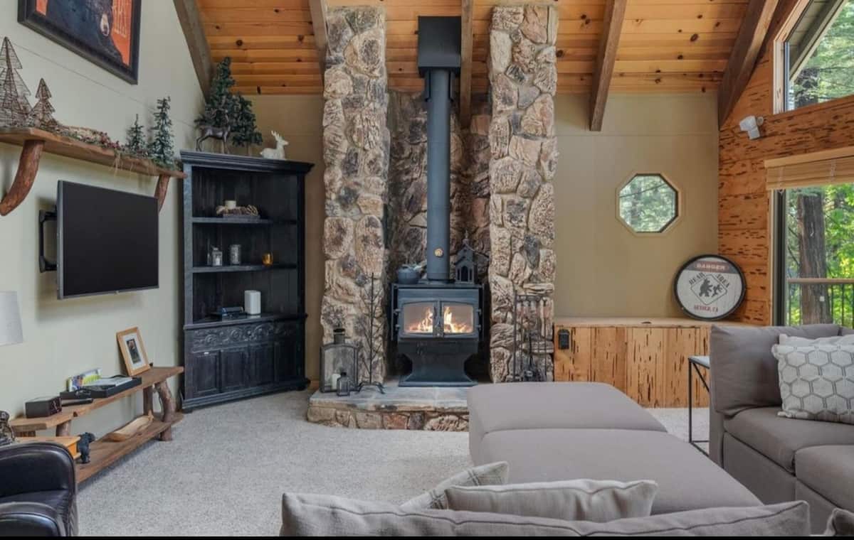 Stone fireplace and forest windows in the main living room