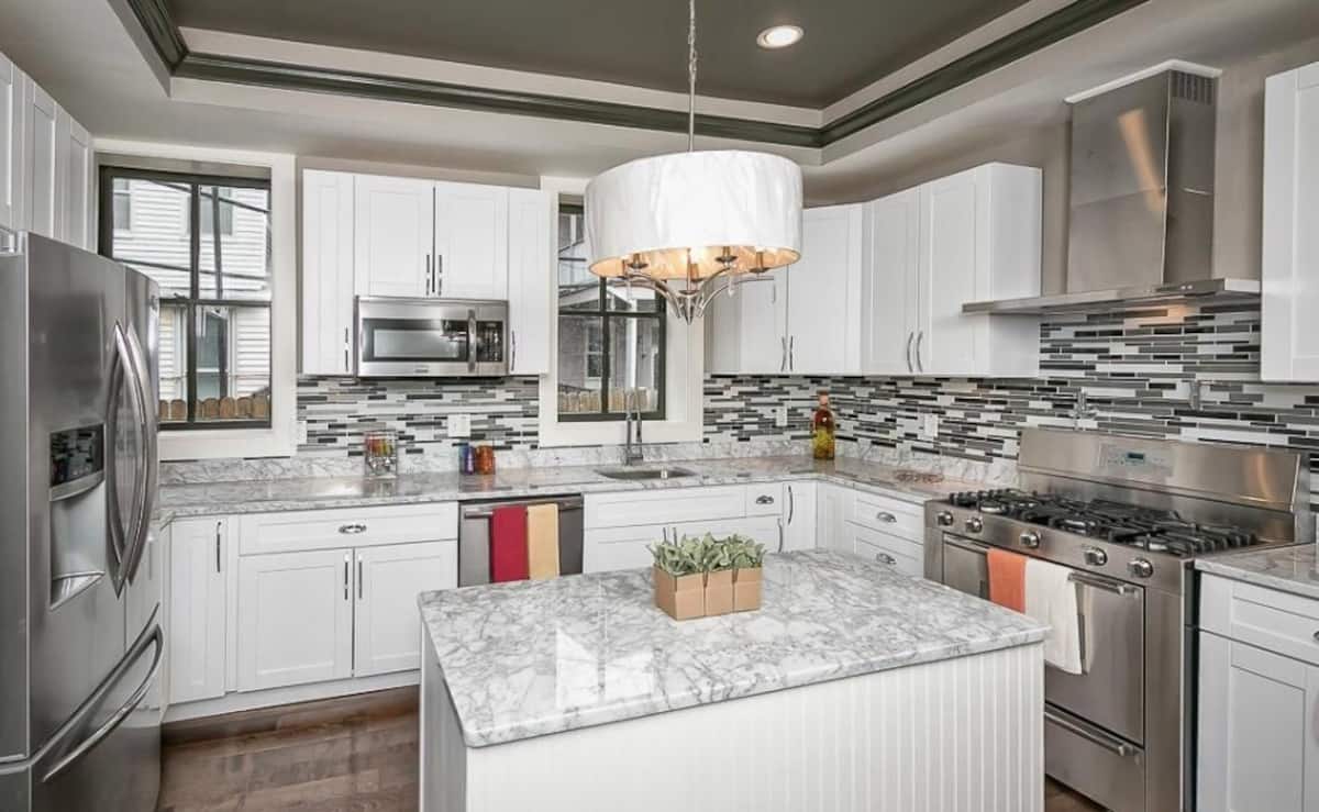 Bright gourmet kitchen with marble counters and a center island
