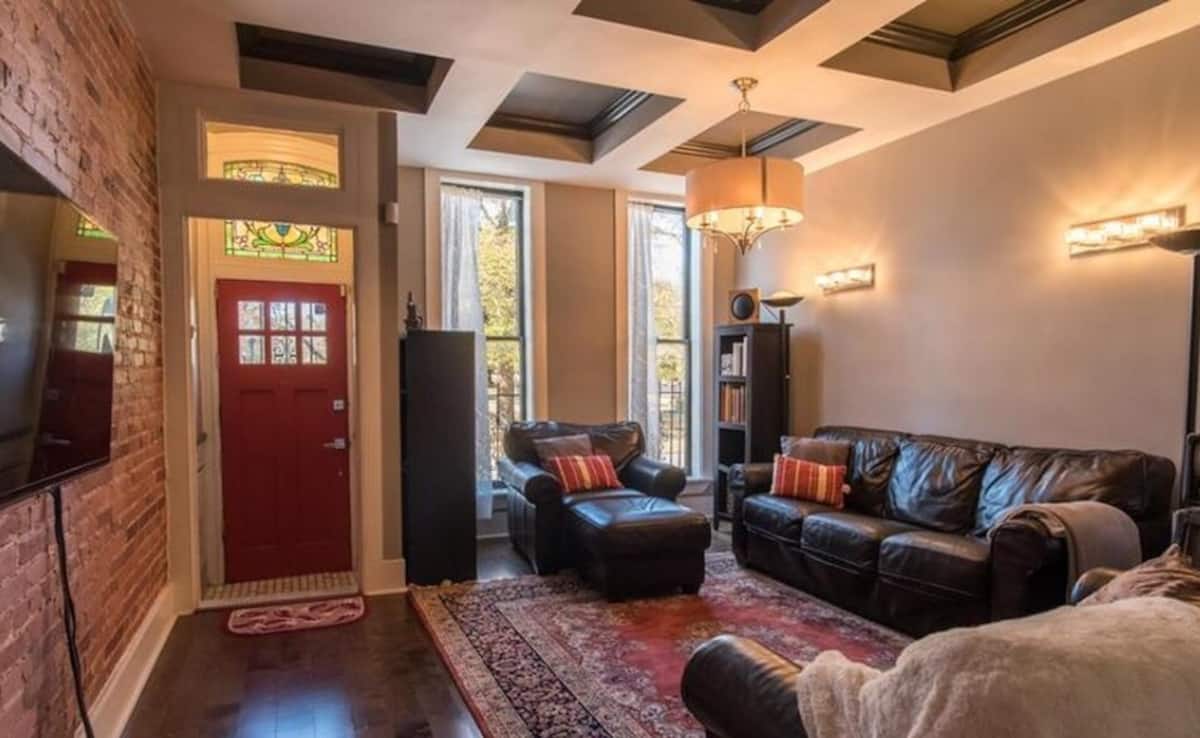 Front living room with leather seating and a red entry door