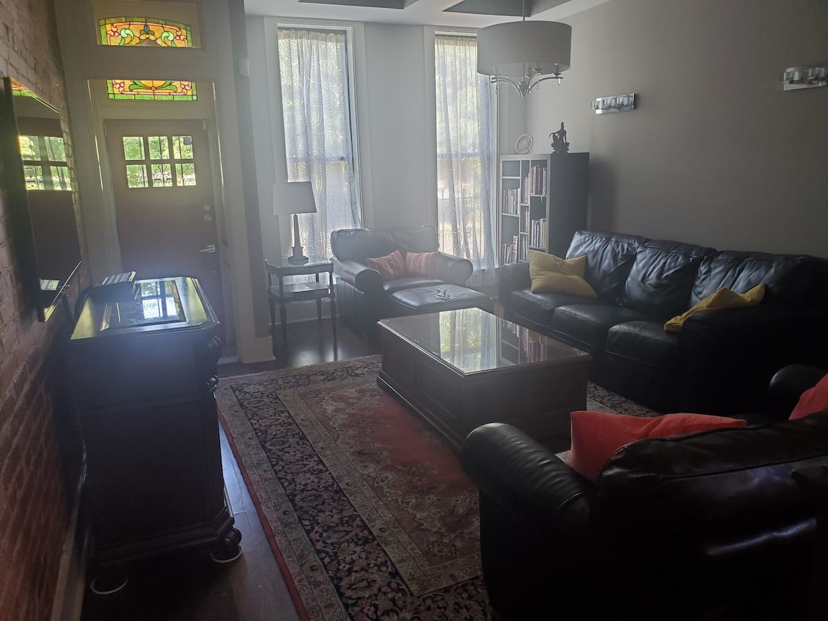 Comfortable living room with leather couches and Persian rug