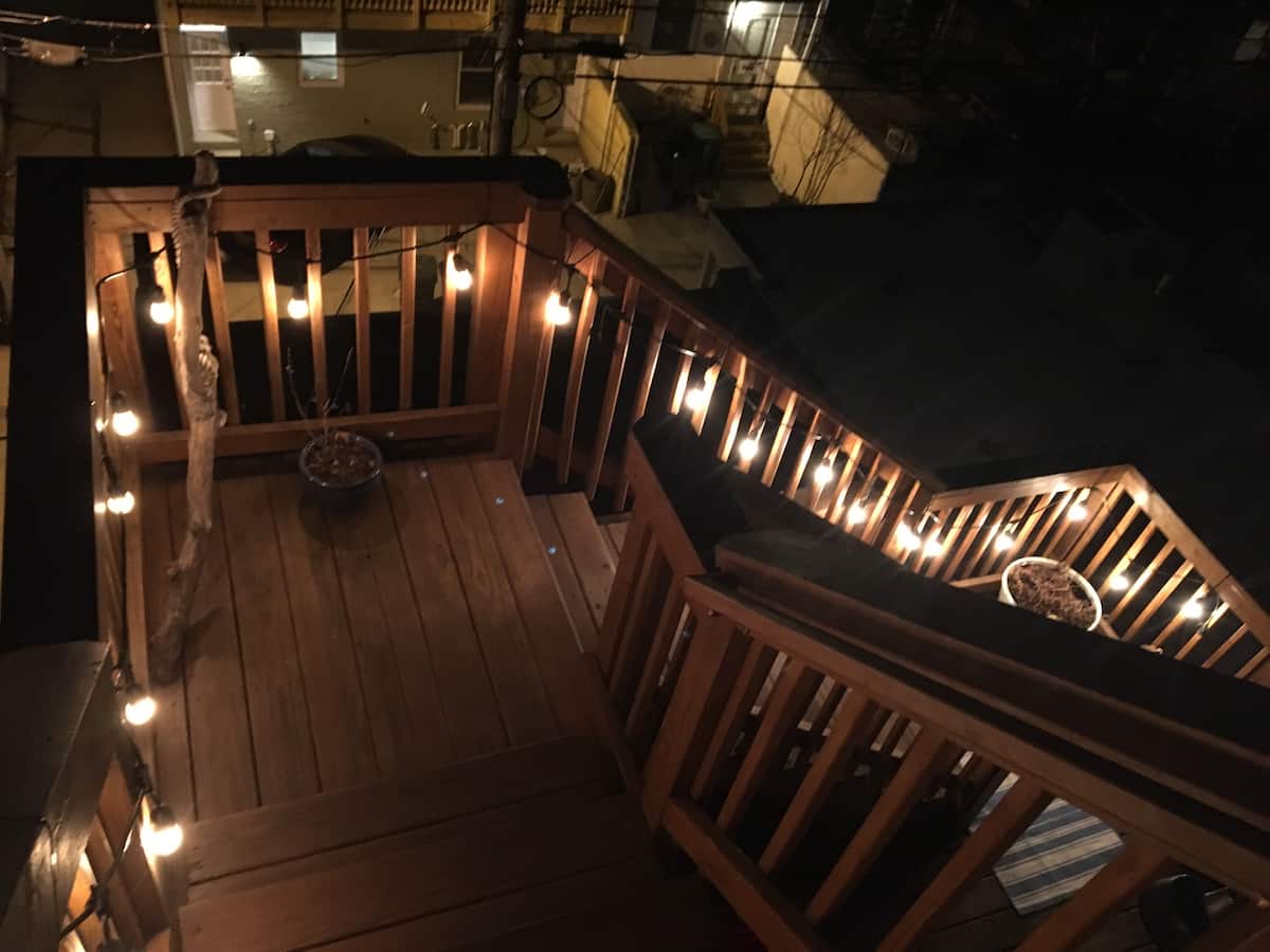 Roof deck stairs wrapped in string lights at night