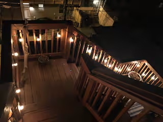 Rooftop deck at night beneath string lights