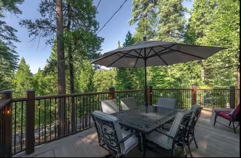 Outdoor dining table on a deck overlooking the trees