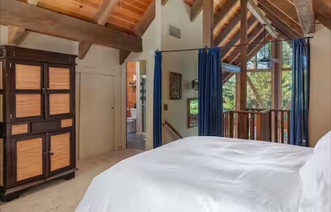 Loft bedroom beneath exposed timber beams